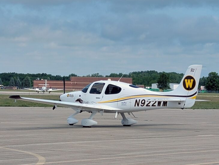 Western Michigan University Cirrus SR20 N922WM with the gold W on its tail, taxiing on the ramp