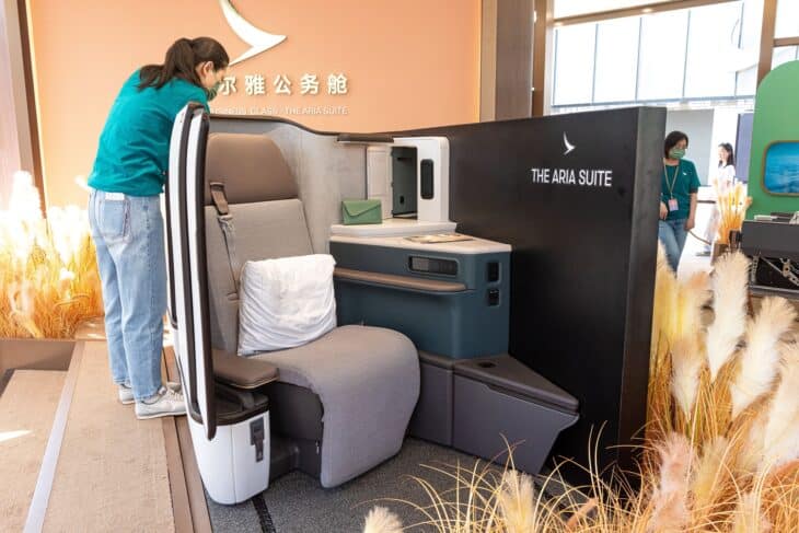 A Cathay Pacific Aria Suite business class seat with its sliding door open, shown at a public display in Beijing
