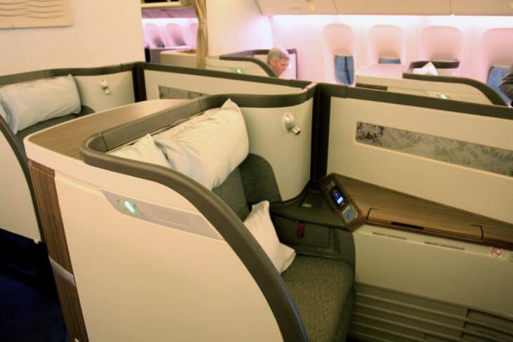 Cathay Pacific Boeing 777-300ER first class seats angled toward the windows, with pillows and a blanket