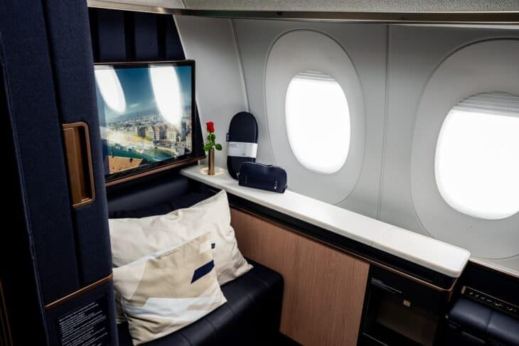 Lufthansa Allegris First single suite with a large screen, a red rose on the window ledge and pillows on the seat