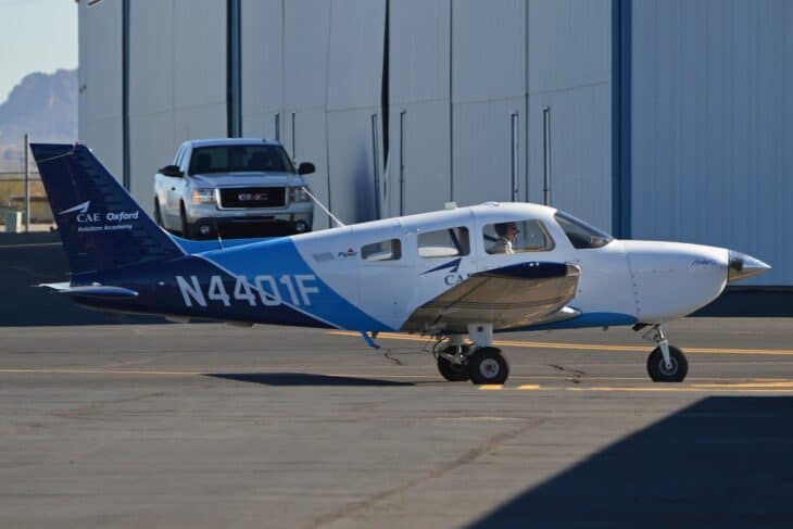 CAE Oxford Aviation Academy Piper PA-28-181 Archer TX N4401F taxiing past a hangar