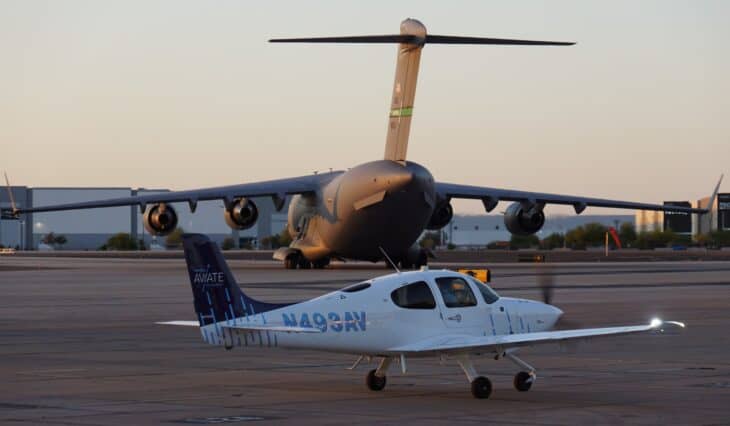 United Aviate Academy Cirrus SR20 N493AV on the ramp at Phoenix Goodyear Airport with a large military transport behind it
