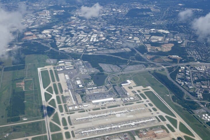 Aerial view of Washington Dulles International Airport, showing its runways, midfield concourses and main terminal surrounded by Northern Virginia suburbs