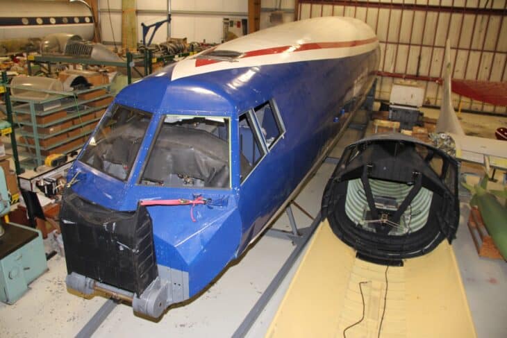 Blue nose and cockpit section of the Boeing 2707 SST mockup under restoration, with the separate droop-nose cone resting beside it