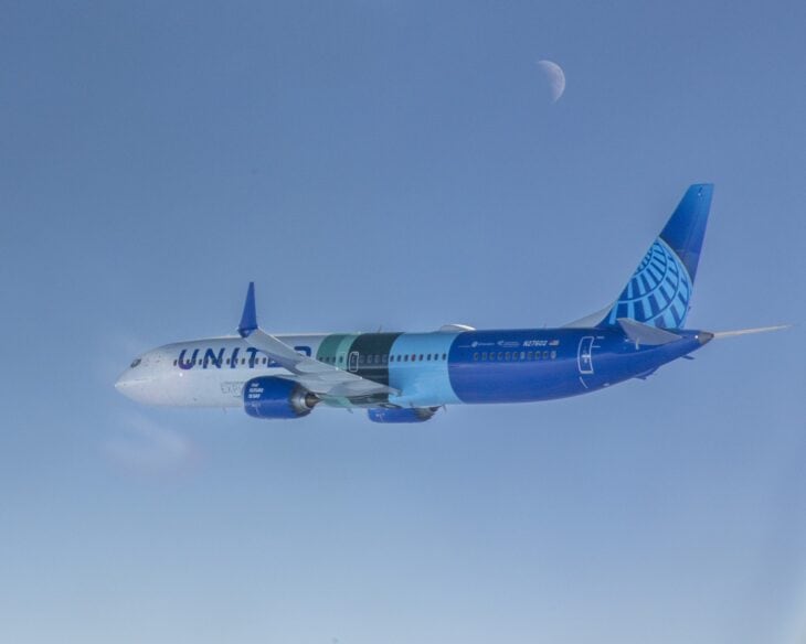 Boeing 737 MAX 10 N27602 in United Airlines livery in flight against a blue sky with the moon above, photographed from NASA's DC-8