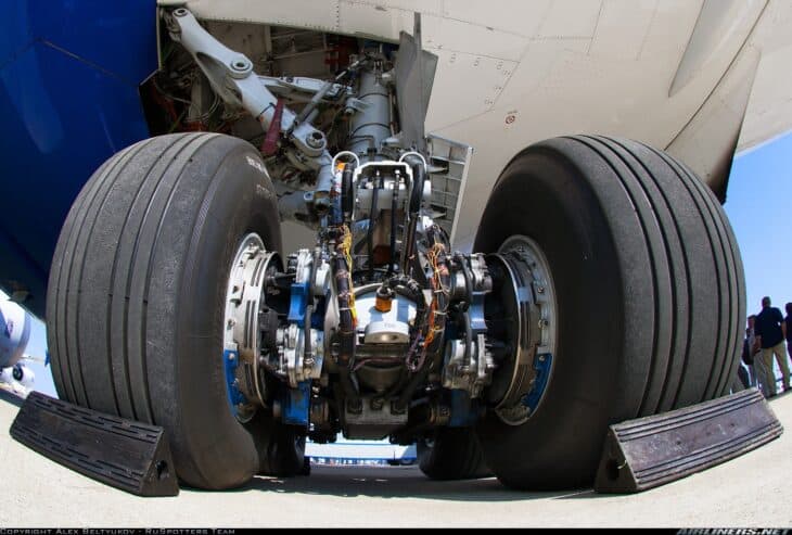 Close-up of the left main landing gear of a Boeing 787-8 showing its tires, wheels and brake assemblies