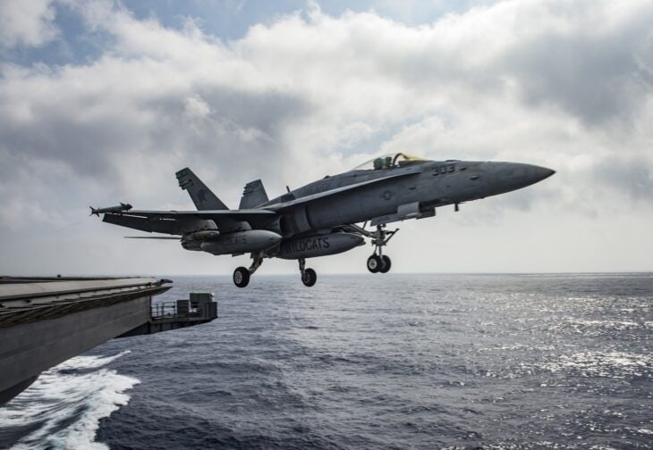 US Navy F/A-18E Super Hornet climbing away from the bow of USS Dwight D. Eisenhower over open sea