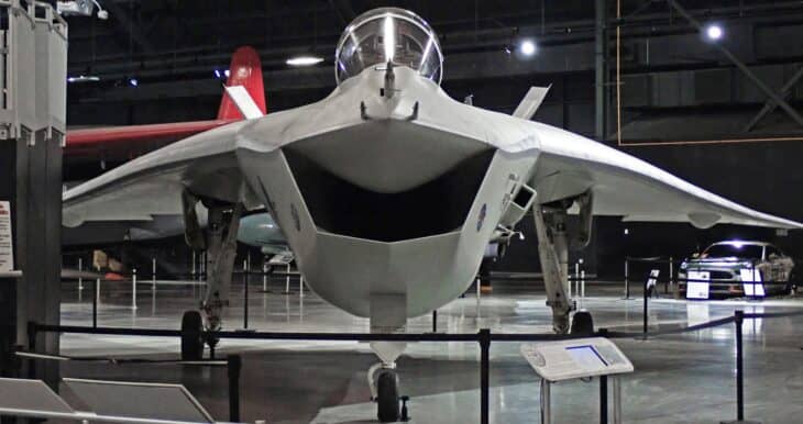 Boeing X-32A demonstrator seen head-on in a museum hangar, showing its wide chin intake and bubble canopy