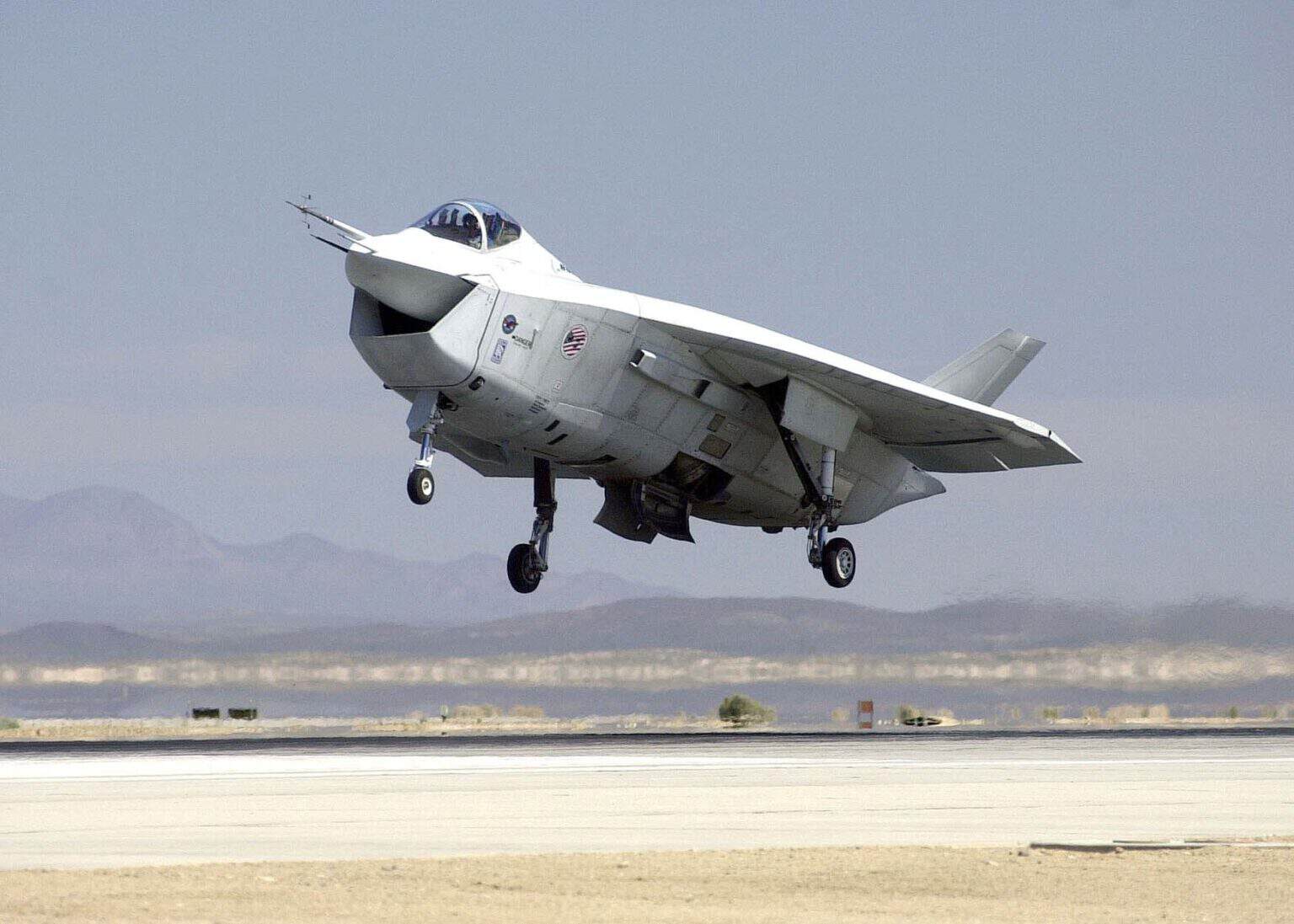 Boeing X-32B Joint Strike Fighter demonstrator with its gear down just above a desert runway, its wide chin intake facing the camera