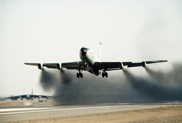KC-135A lifting off trailing thick black smoke from its four J57 turbojets during a water-injected takeoff