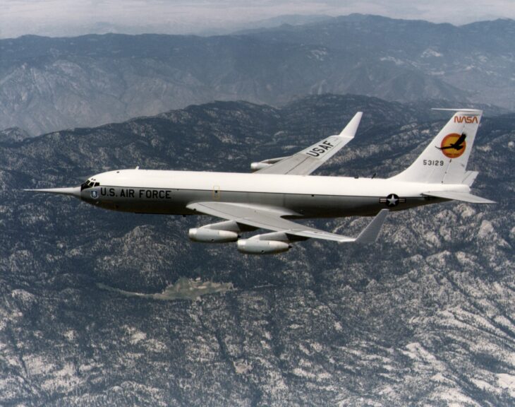 White NASA KC-135A 55-3129 with upright winglets on its wingtips flying over the San Gabriel Mountains