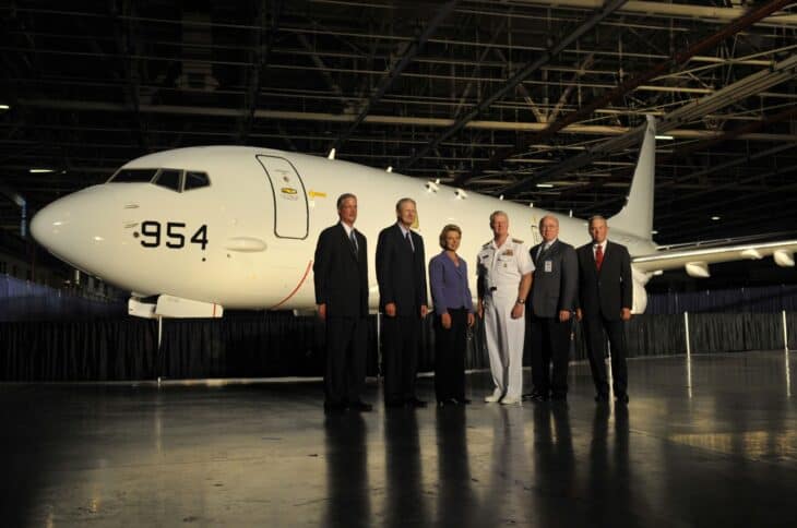 Boeing P-8A Poseidon test aircraft 167954 in a hangar with Navy and Boeing officials lined up in front of it
