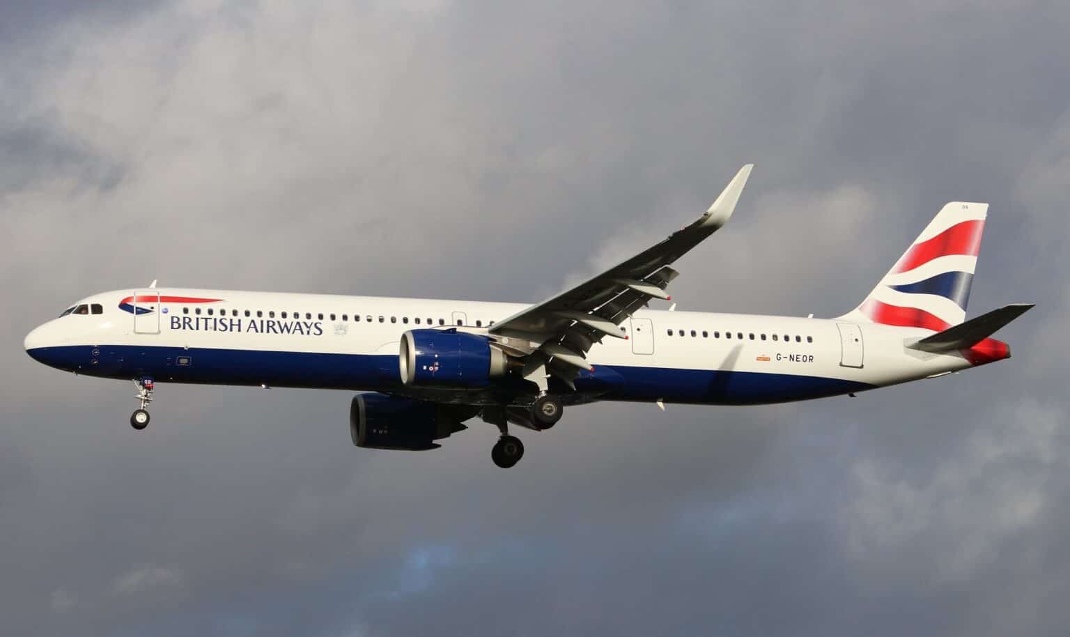 British Airways Airbus A321neo G-NEOR on approach with its landing gear down under a dark, cloudy sky