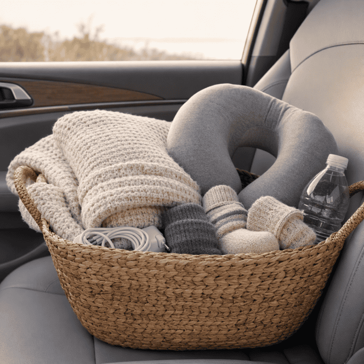 A blanket, a neck pillow and a charger on the passenger seat make a long flight easier to recover from.