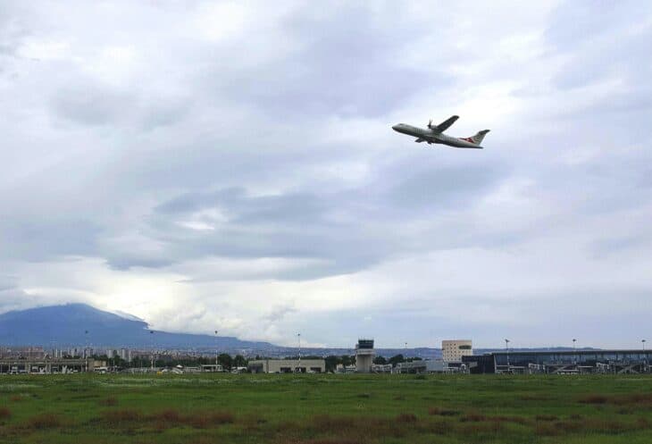 A jet climbing out of Catania-Fontanarossa Airport with Mount Etna and the control tower in the background