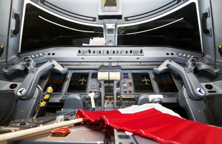 Flight deck of an Embraer 175 showing the separate windshield panels in front of each pilot seat