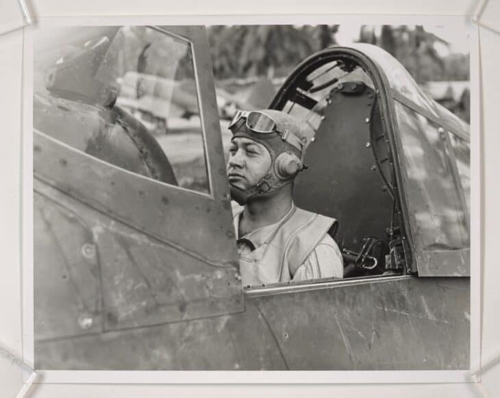 Pappy Boyington in the cockpit of his fighter, wearing a flight helmet and goggles