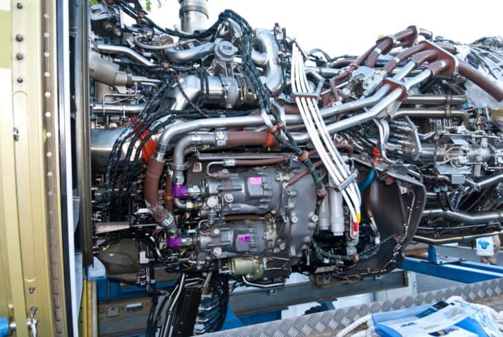 General Electric CF6-80E1 turbofan without its nacelle on a transport stand, showing the pipes and accessories around the engine core