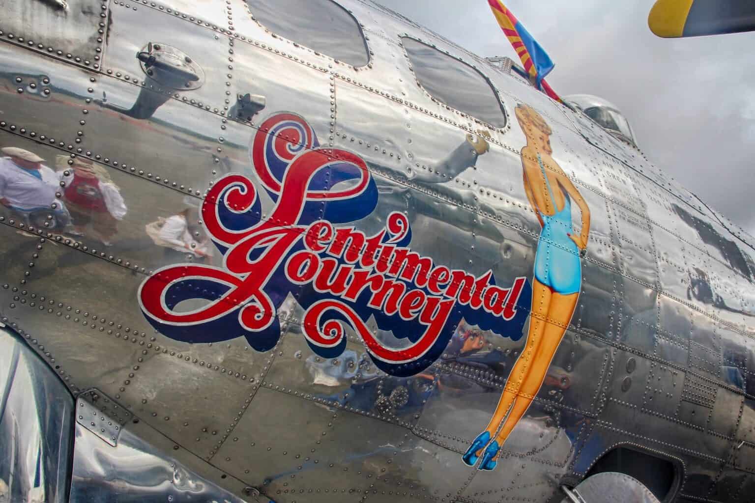 Close-up of the Sentimental Journey script and pin-up nose art on the polished aluminium fuselage of B-17G N9323Z