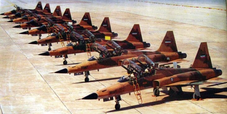 A row of IRIAF Northrop F-5 Tiger II fighters in desert camouflage parked on a ramp during the Iran-Iraq war