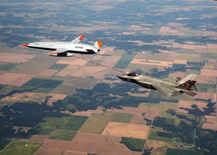 MQ-25 Stingray test aircraft refueling an F-35C fighter over farmland