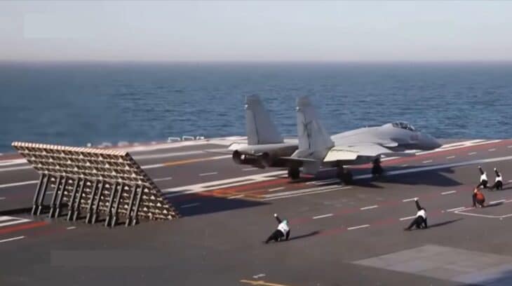 A Shenyang J-15T fighter hooked to an electromagnetic catapult on the flight deck of the Chinese aircraft carrier Fujian, jet blast deflector raised