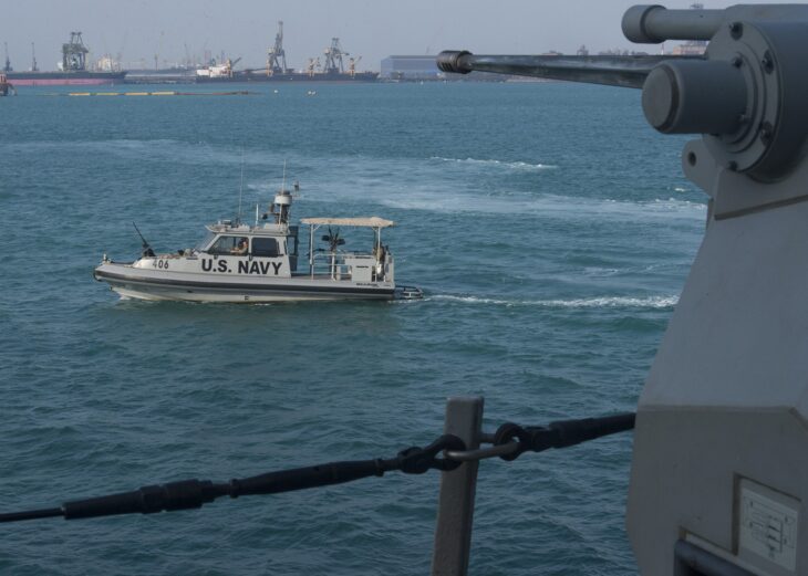 A small US Navy coastal riverine patrol boat escorting the much larger guided missile destroyer USS Mitscher in the Arabian Gulf