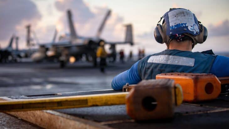 A US Navy sailor watching flight deck operations aboard the aircraft carrier USS Gerald R. Ford at sea in the Caribbean