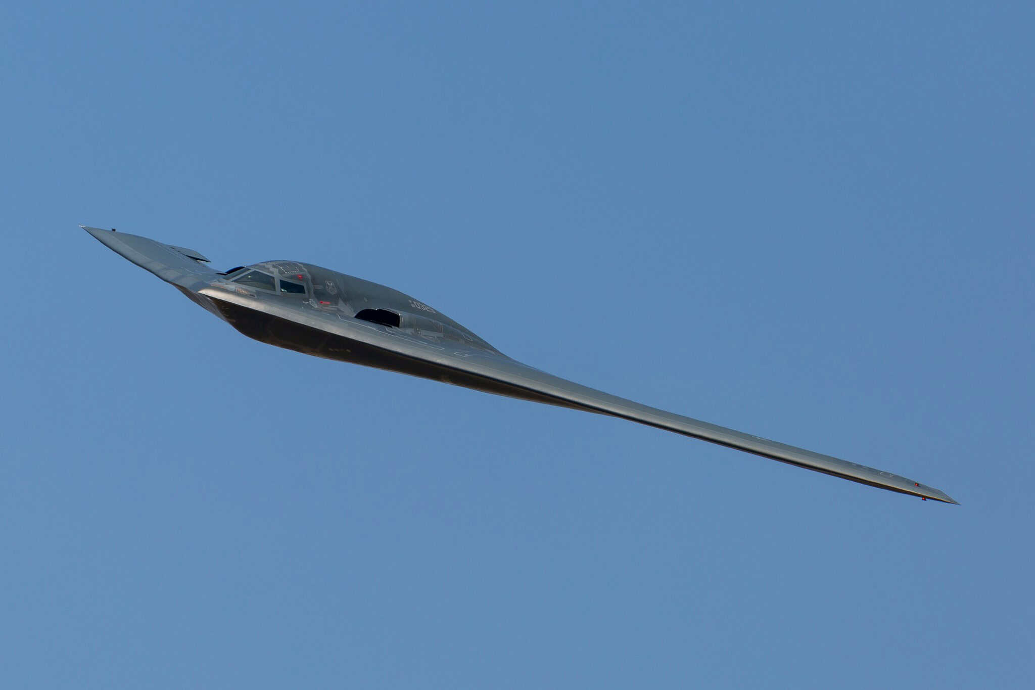 Northrop Grumman B-2 Spirit stealth bomber in flight, seen in planform against a clear sky