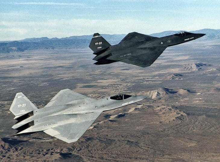 The dark gray YF-23 PAV-1 and the lighter gray PAV-2 flying in formation over the Mojave Desert