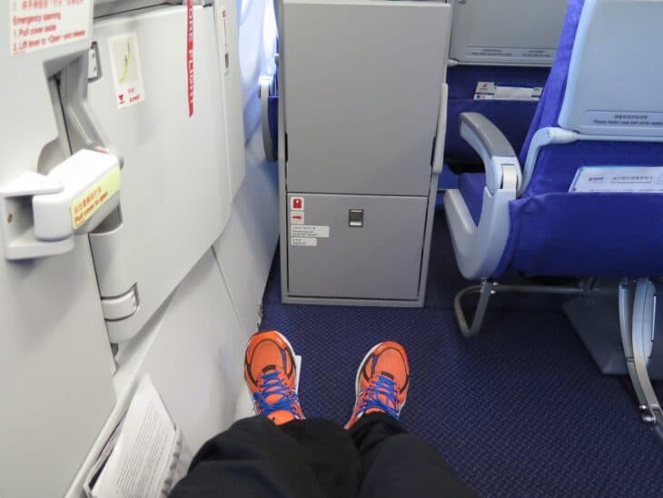 View from an exit-row seat toward the emergency door, with open legroom beside it