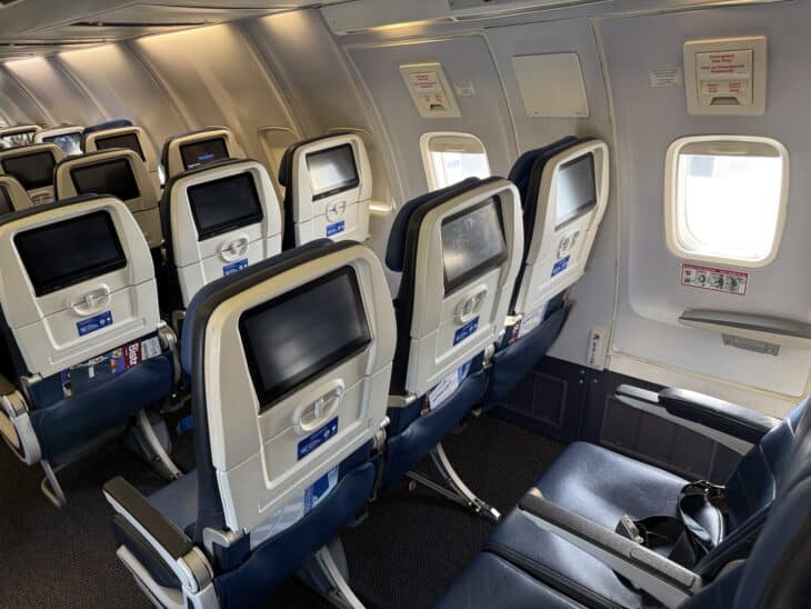 Overwing emergency exit row on a United Boeing 757-200 with the exit handle placard above the window
