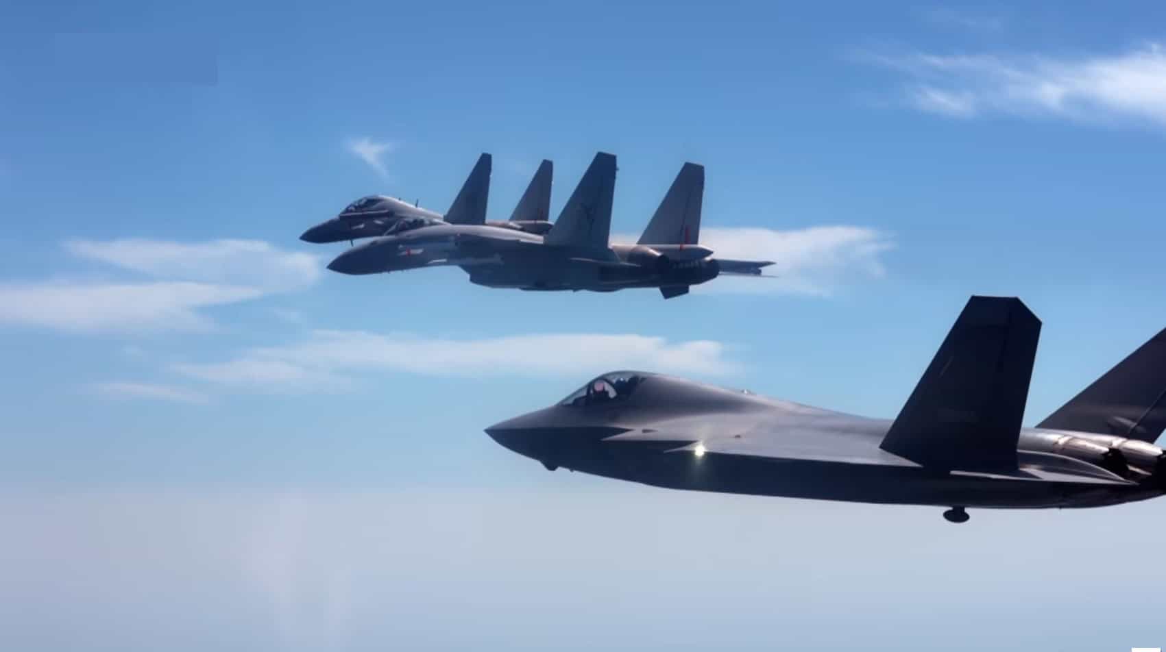 Shenyang J-35 stealth fighter flying in formation with a Shenyang J-15T