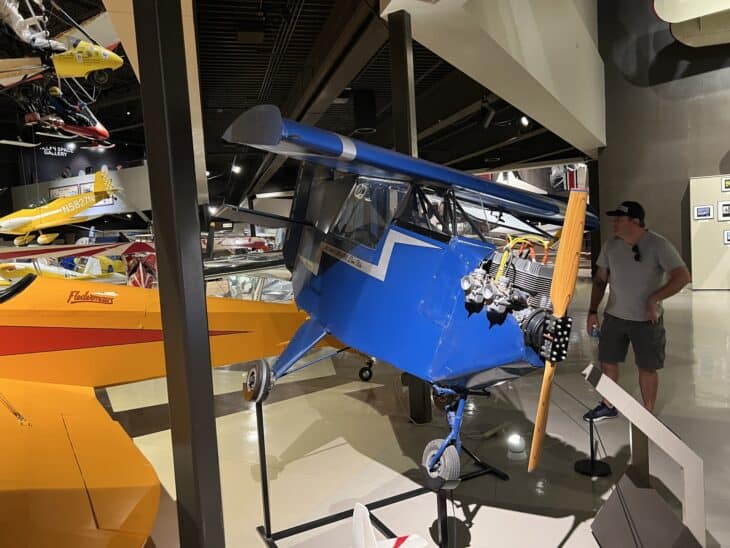 Blue Stits DS-1 Baby Bird N4453H on display at the EAA Aviation Museum, with a visitor standing beside it