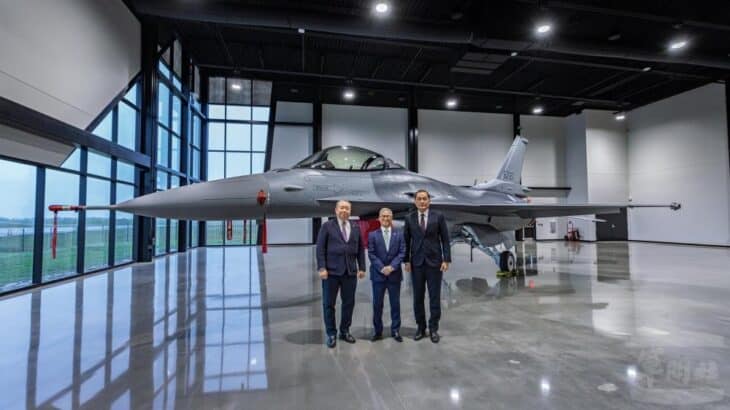 Three Taiwanese defense officials standing in a hangar in front of a newly assembled Republic of China Air Force F-16 Block 70 fighter