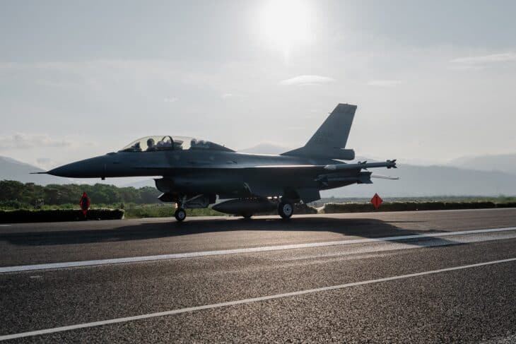 Republic of China Air Force F-16 fighter on a highway emergency runway at sunrise, with mountains behind it