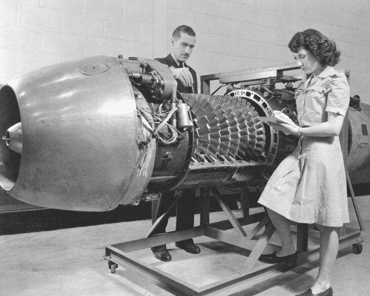 Engineers study a Junkers Jumo 004 turbojet with its cover removed, showing the axial compressor blades, at the Aircraft Engine Research Laboratory in 1946