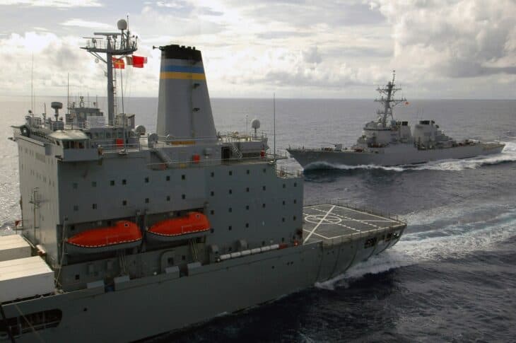 A guided missile destroyer steaming close alongside a fleet replenishment oiler during an underway replenishment