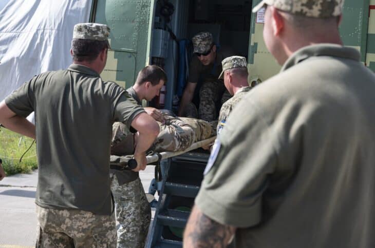 Ukrainian Air Force personnel loading a patient on a stretcher into a Mil Mi-8 helicopter