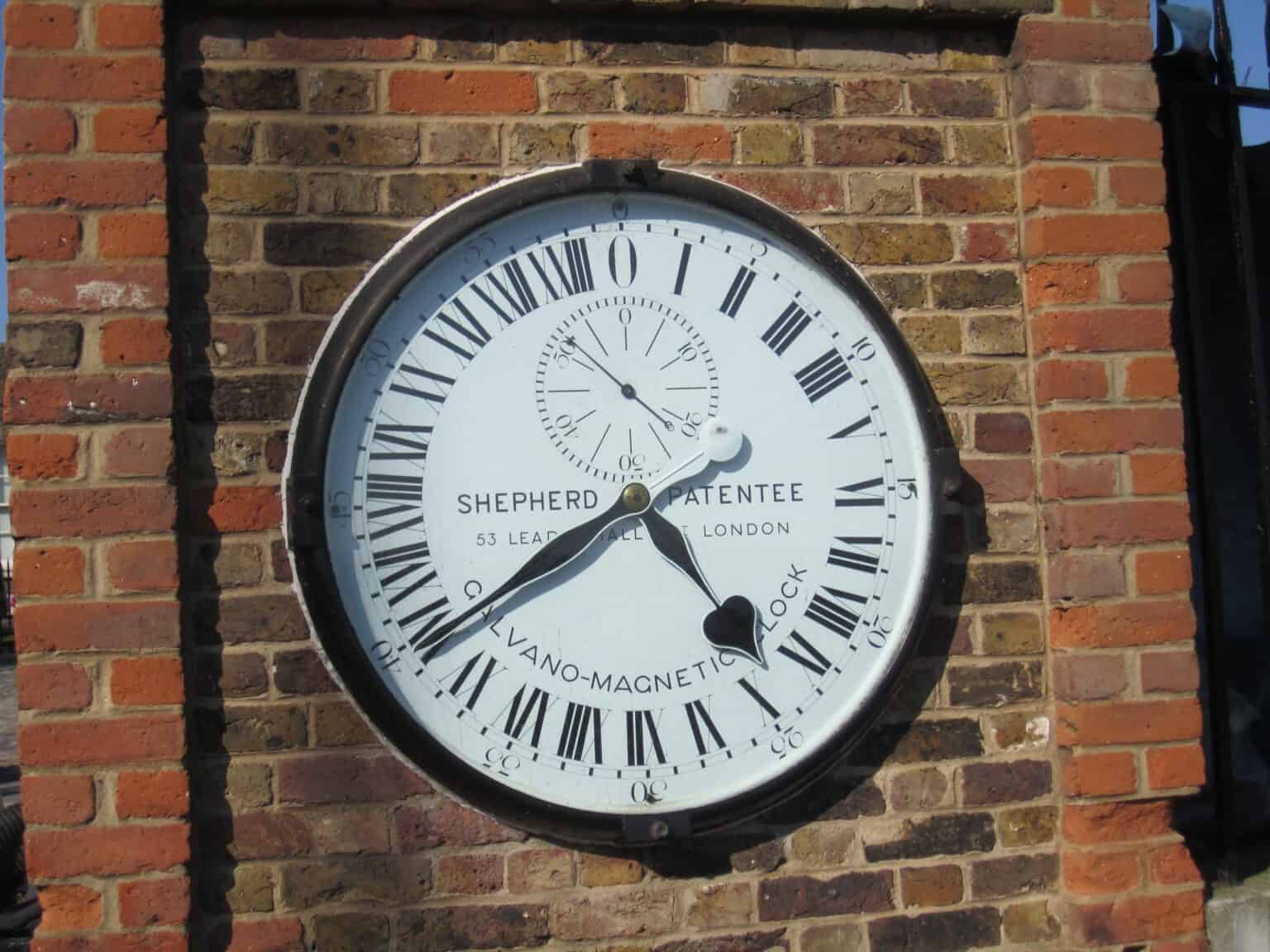 The 24-hour Shepherd Gate Clock set into a brick wall at the Royal Observatory, Greenwich