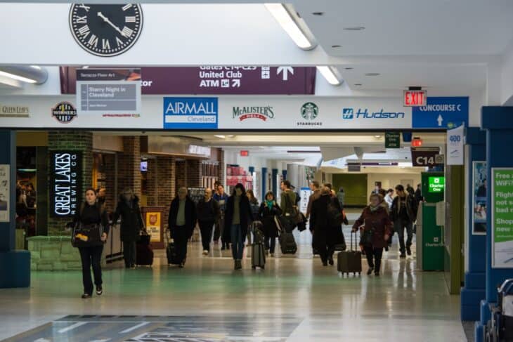 Passengers walking past retail units along Concourse C at Cleveland Hopkins International Airport
