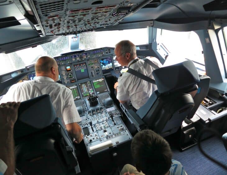 Two pilots at work on the flight deck of an Airbus A380 with the instrument panel displays in front of them