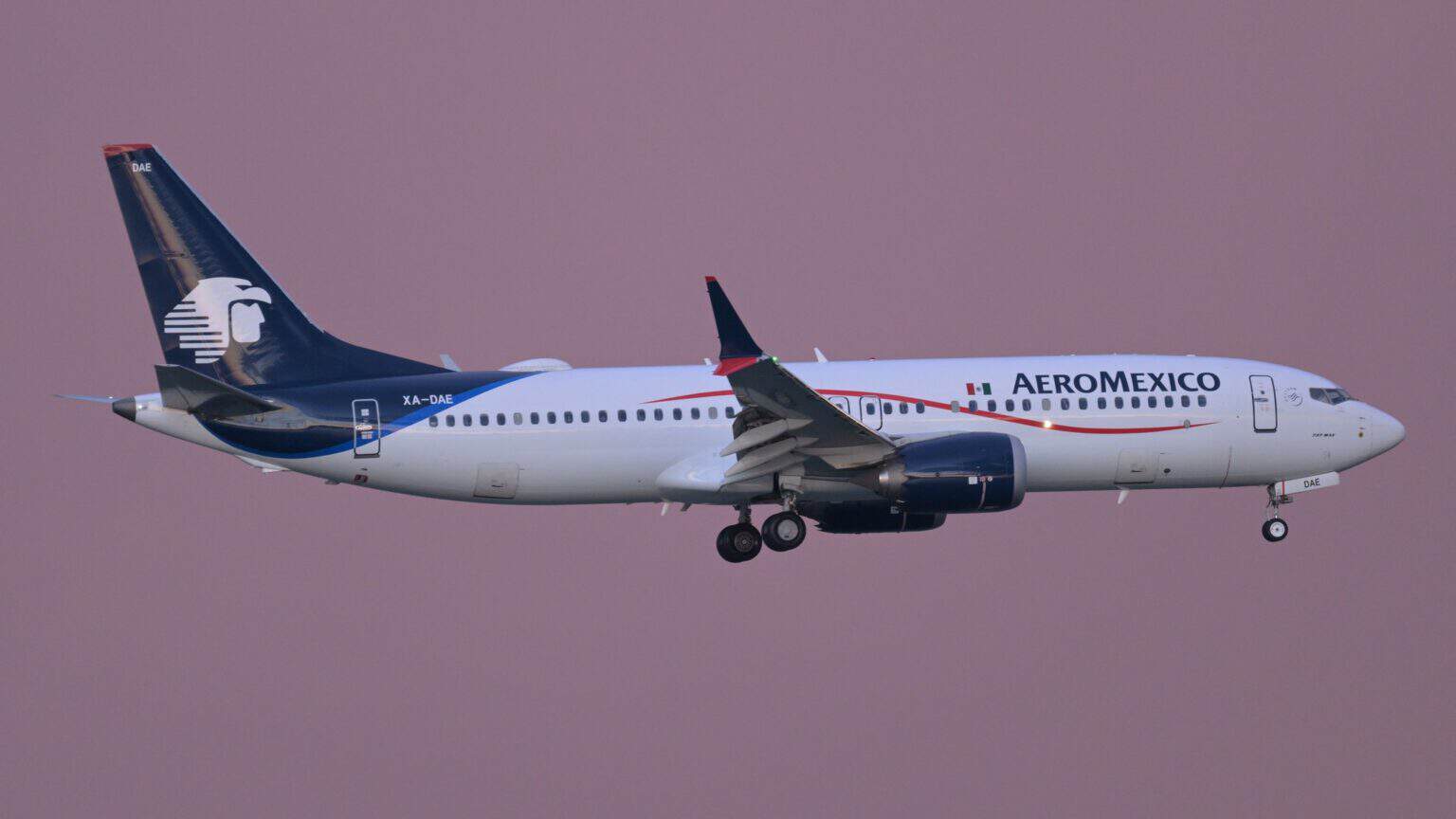 Aeromexico Boeing 737-8 MAX XA-DAE on final approach with gear down against a pink dusk sky