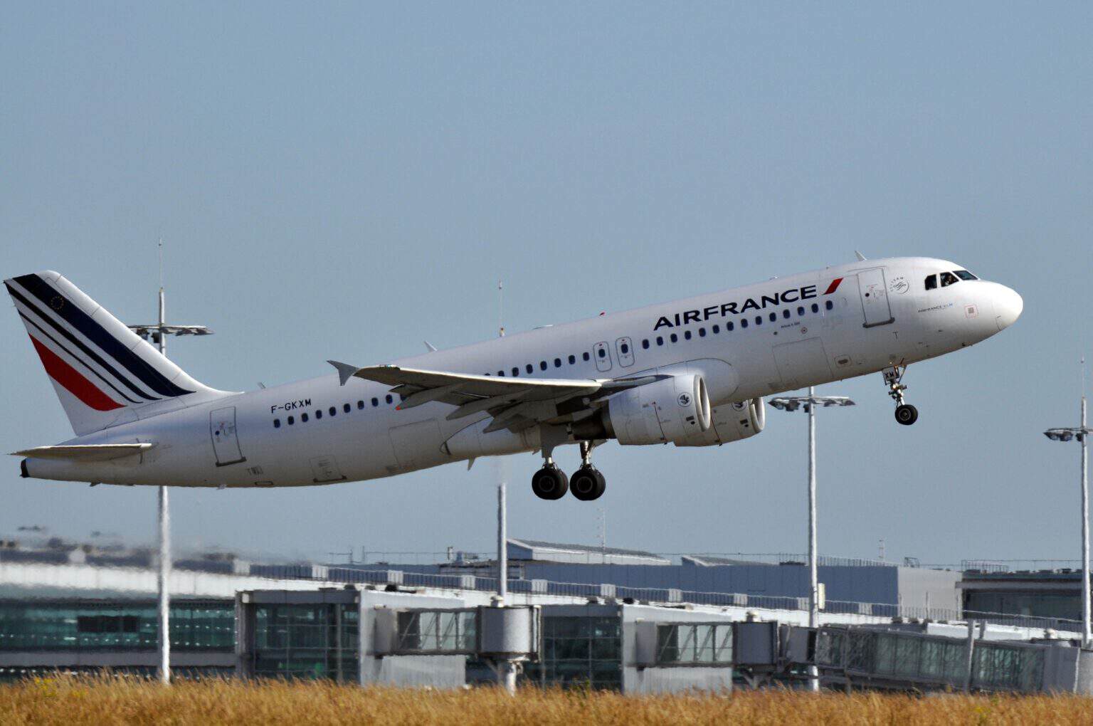 Air France Airbus A320 F-GKXM lifting off from Paris Charles de Gaulle with the terminal behind it