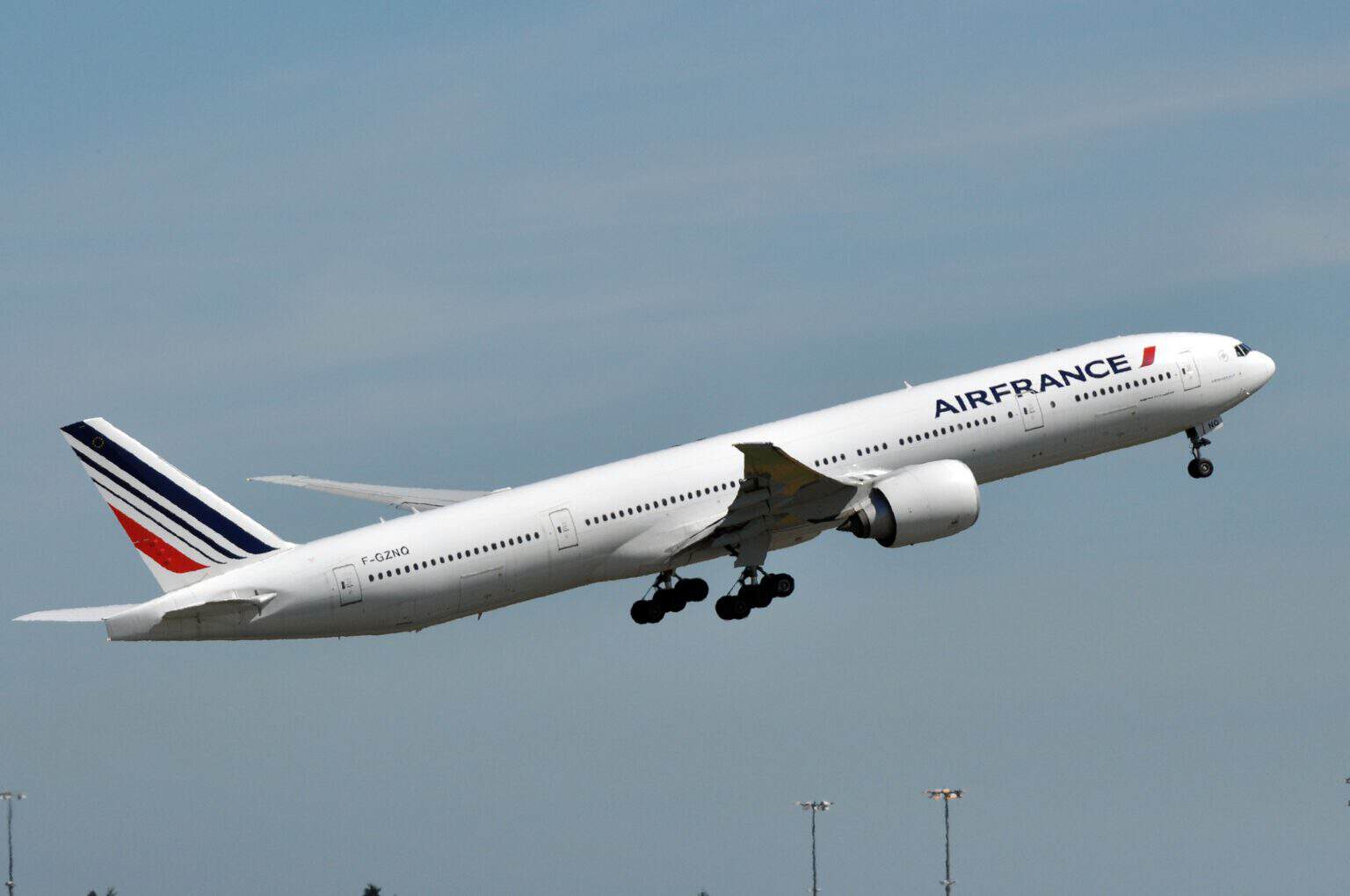 Air France Boeing 777-300ER F-GZNQ climbing away after takeoff with its landing gear still down