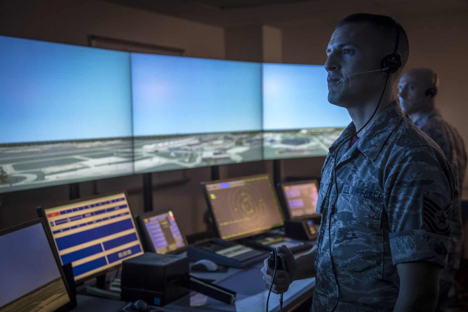 Air National Guard air traffic controllers working in a tower simulator with wraparound screens