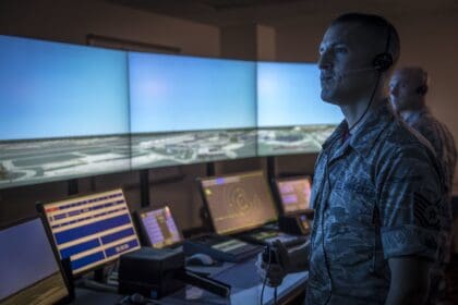 Air National Guard air traffic controllers working in a tower simulator with wraparound screens