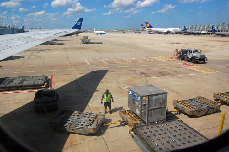 Baggage carts and a tug on the apron at Chicago O'Hare International Airport, seen from an aircraft window