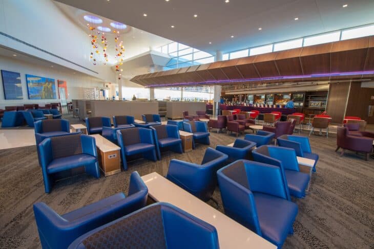 Delta Sky Club seating area and bar at Atlanta airport with blue armchairs