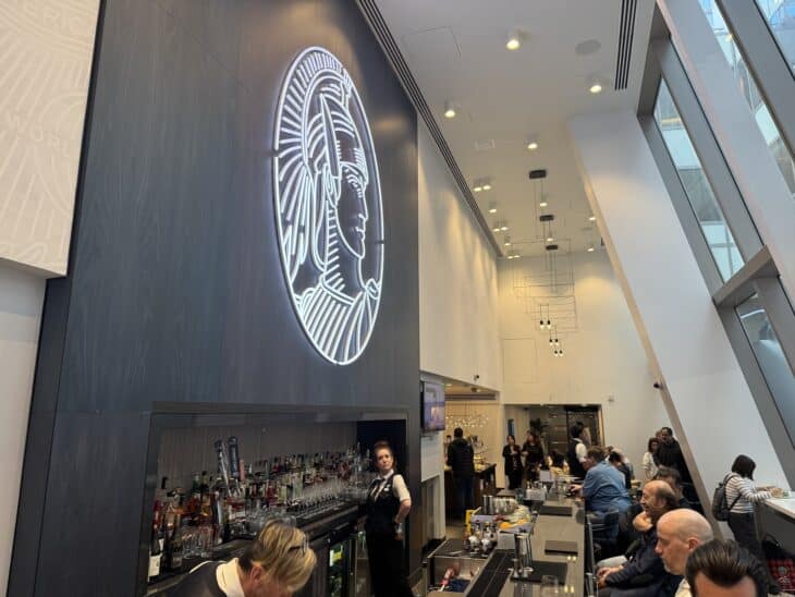Bar and illuminated Centurion emblem inside the American Express Centurion Lounge at Los Angeles airport